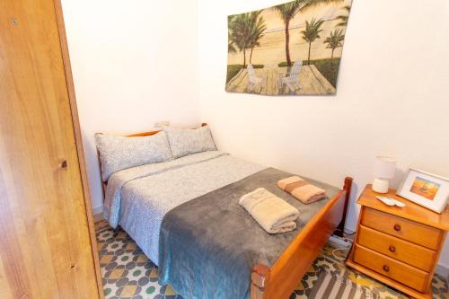a small bedroom with a bed and a night stand at RentitSpain Casa Abanico a pasos de Castillo de Salobreña in Salobreña