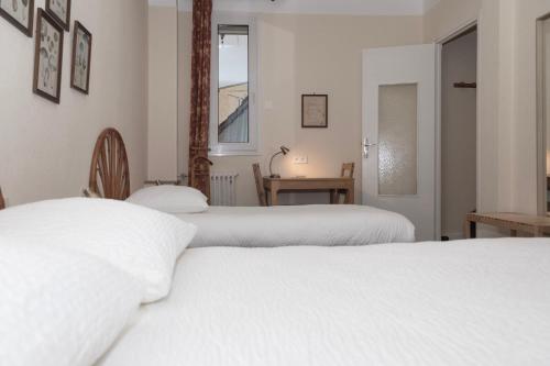 two white beds in a room with a window at Cit'Hotel Aéro-Hotel in Le Blanc-Mesnil