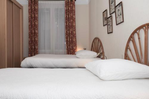 two beds sitting next to each other in a bedroom at Cit'Hotel Aéro-Hotel in Le Blanc-Mesnil