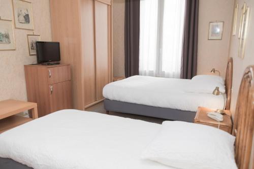 a hotel room with two beds and a television at Cit'Hotel Aéro-Hotel in Le Blanc-Mesnil