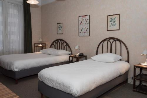 a hotel room with two beds and two lamps at Cit'Hotel Aéro-Hotel in Le Blanc-Mesnil