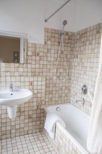 a bathroom with a tub and a sink and a shower at Cit'Hotel Aéro-Hotel in Le Blanc-Mesnil