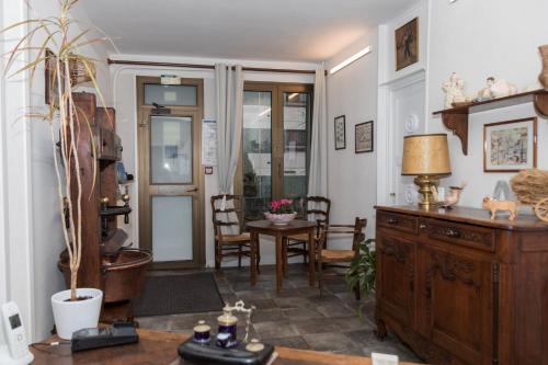 a living room with a wooden cabinet and a table at Cit'Hotel Aéro-Hotel in Le Blanc-Mesnil