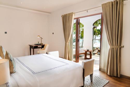 a bedroom with a large white bed and a patio at Angel Beach Unawatuna in Unawatuna
