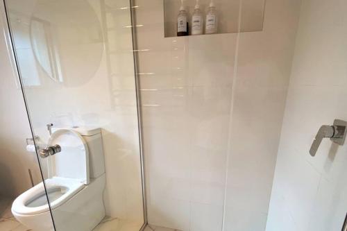 un bagno bianco con wc e doccia di Skyview Cottage a Leura