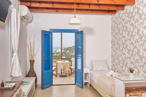 a bedroom with a blue door leading to a balcony at Amorgion Village in Katapola