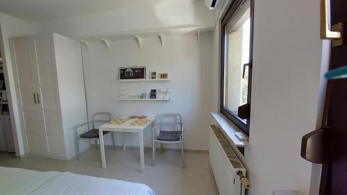 een kleine kamer met een tafel en 2 stoelen bij Cozy, Bright and Affordable Studio w/ FREE Parking in Ljubljana