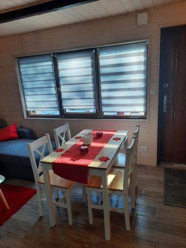 a dining room table and chairs with a red table cloth at DOMKI RODIS in Baligród