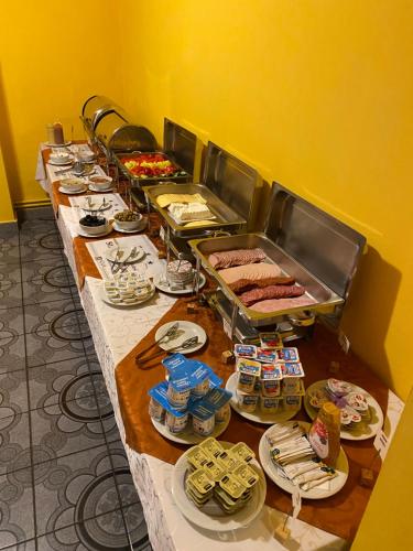 a long table with plates of food on it at Hotel Dobsi in Bazna