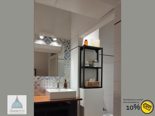 ein Bad mit einem Waschbecken und einem Spiegel in der Unterkunft Casa Samarotto in Reggio nell'Emilia