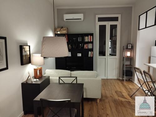 ein Wohnzimmer mit einem weißen Sofa und einem Tisch in der Unterkunft Casa Samarotto in Reggio nell'Emilia