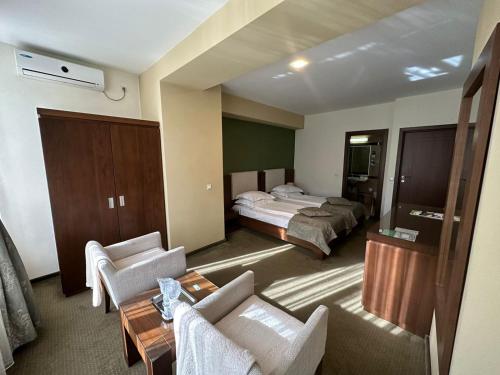 ein Hotelzimmer mit einem Bett und einem Wohnzimmer in der Unterkunft Hotel Royale in Galaţi