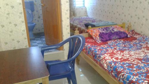 1 dormitorio con 1 cama, 1 mesa y 1 silla en Happy Tourist Home Neyyardam, en Parattipalli