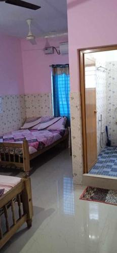 1 dormitorio con 2 camas y puerta a una habitación en Happy Tourist Home Neyyardam, en Parattipalli