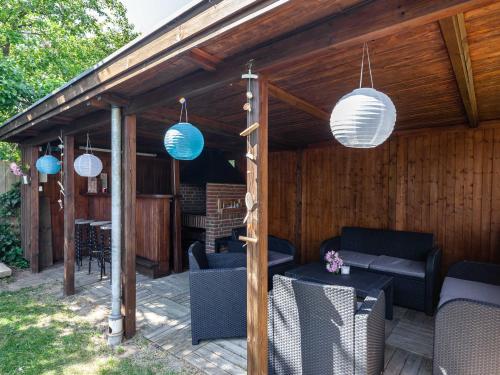 a wooden patio with blue and white lanterns at Ferienhaus REETselig mit Pool Sauna in Klein Barkau