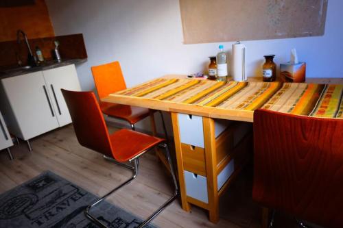 a kitchen with a wooden counter with orange chairs at Casa Colore with Garden and Courtyard in Wiesbaden