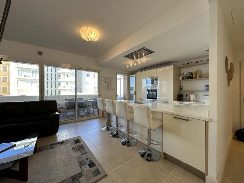 - une cuisine avec un bar et des tabourets dans la chambre dans l'établissement C028-Nice apartment with terrace - close to the beach, à Cannes