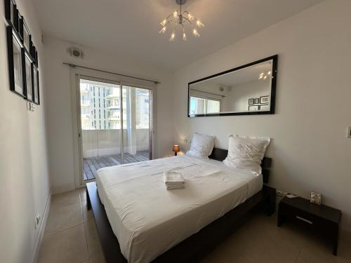 une chambre avec un grand lit et un miroir dans l'établissement C028-Nice apartment with terrace - close to the beach, à Cannes