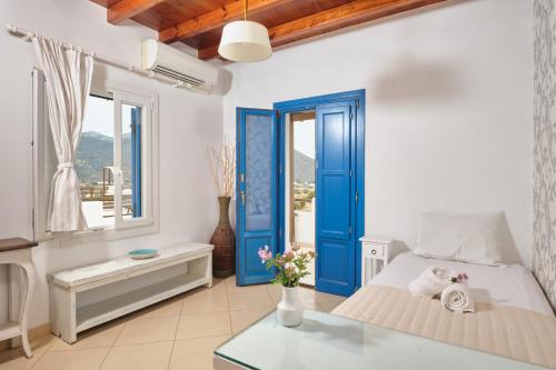 a bedroom with a blue door and a bed at Amorgion Village in Katapola