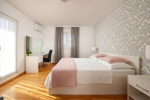 Habitación blanca con cama y escritorio en VILLA MILLA with private pool, jacuzzi, sauna, gym, max. 8 person, en Srinjine