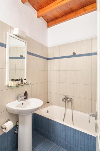a bathroom with a sink and a bath tub at Amorgion Village in Katapola