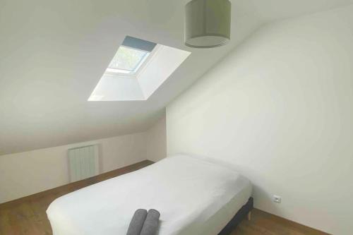 une chambre avec un lit blanc et une fenêtre dans l'établissement Superbe appartement en coeur de ville, à Orléans