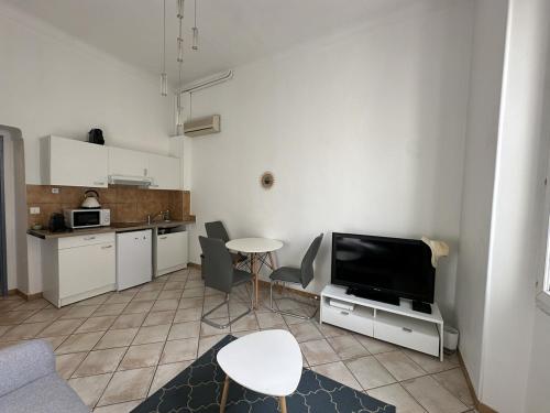 un salon avec une table et une télévision et une cuisine dans l'établissement C034-Appt fonctionnel - Centre Cannes, à Cannes