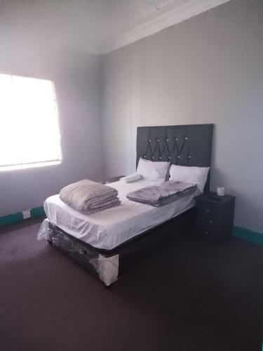 een slaapkamer met een groot bed en een raam bij Prime Guest Inn in Benoni