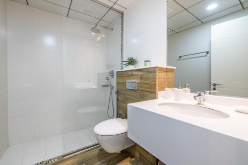 a white bathroom with a toilet and a sink at 1 Bedroom Apartment with city view in Dubai