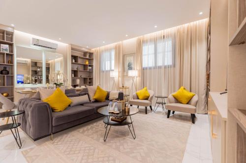 a living room with a couch and yellow pillows at Amber Al Qairwan in Riyadh