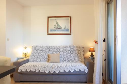 a living room with a couch and a picture of a sailboat at Studio proche des plages in Le Pradet