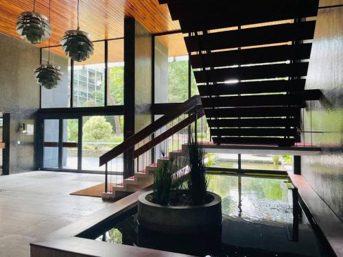 une maison avec un étang et un escalier avec une plante en pot dans l'établissement Vue mer : La Canopée à La Baule, à La Baule