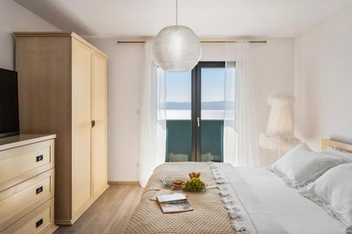 Schlafzimmer mit einem Bett, einem TV und einem Tisch in der Unterkunft Villa Allegra with 32msq heated pool, 300m far from sandy beaches, open sea view in Omiš