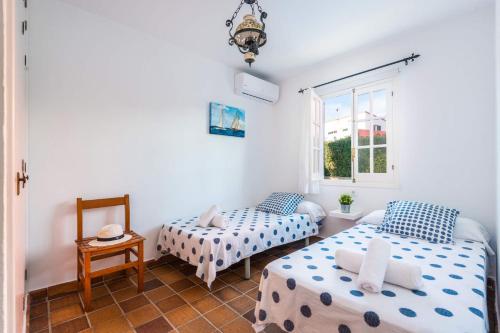 Cette chambre comprend 2 lits et une fenêtre. dans l'établissement Villa Can Bolduc by Villa Plus, à Cala en Blanes