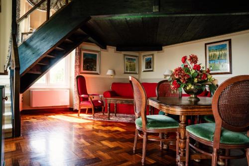 a dining room with a table and chairs and a couch at Relais Villa Pomela in Novi Ligure