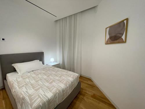sypialnia z łóżkiem i zdjęciem na ścianie w obiekcie IMHOME - Dante w Mediolanie