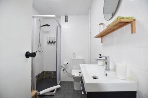 a white bathroom with a sink and a shower at Le Studio. Único, acogedor y en el centro de Vigo. in Vigo
