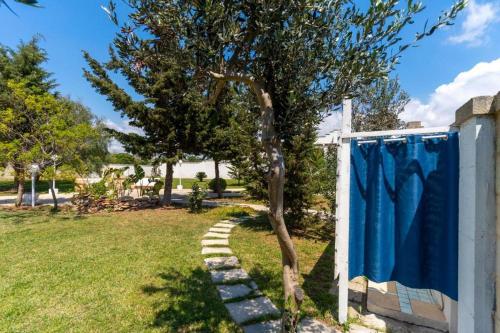 a tree with a blue towel hanging on a fence at Villa Dei Lidi - HomeSalento com in Torre San Giovanni Ugento