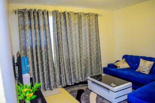 a living room with a blue couch and a window at ROYALSTAYCATION in Ruiru