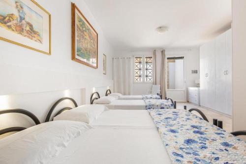 eine Reihe weißer Betten in einem Zimmer in der Unterkunft Villa Dei Lidi - HomeSalento com in Torre San Giovanni Ugento