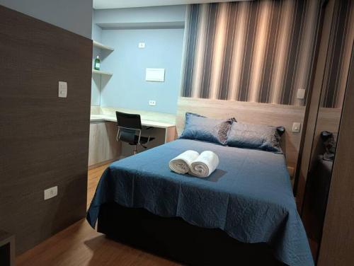 a bedroom with a bed with two towels on it at Stay GRU - Loft Completo próx GRU airport - Guarulhos in Guarulhos