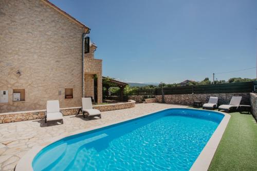 una piscina con sillas y una casa en Kalpic Suites & Villa en Lozovac