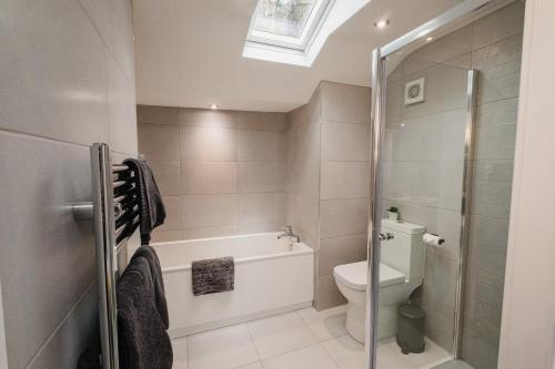 a bathroom with a shower and a toilet and a sink at Swan House in Huddersfield