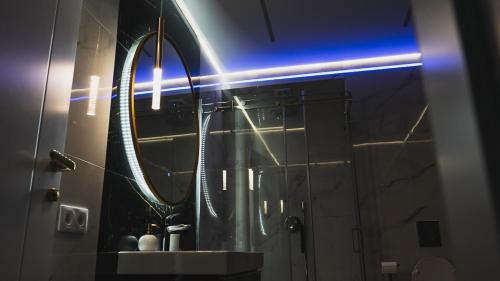 a bathroom with a mirror and a sink at Premium Sky Jacuzzi Apartment in Klaipėda