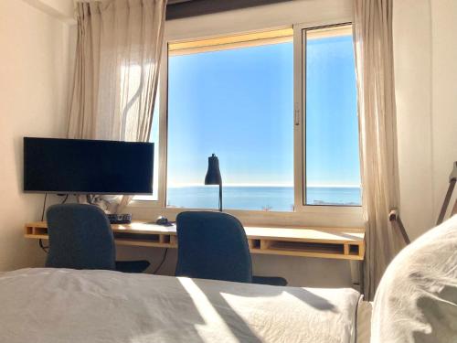 a bedroom with a desk with a computer and a window at Beautiful Mediterranean views in central Torremolinos in Torremolinos