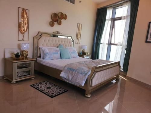 a bedroom with a large bed and a window at LuxeHome where blue sea & white sands greets you in Ajman