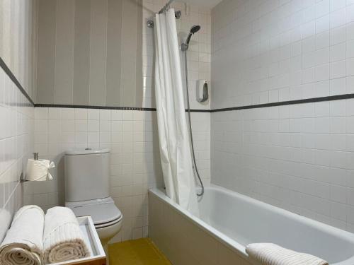 bagno bianco con vasca e servizi igienici di Apartamentos Ciudad Santiago a Santiago de Compostela