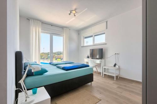 a bedroom with a bed and a desk and a television at Aura in Pula