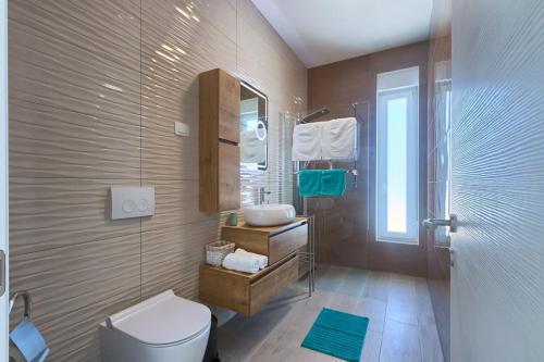 a bathroom with a toilet and a sink and a shower at Aura in Pula