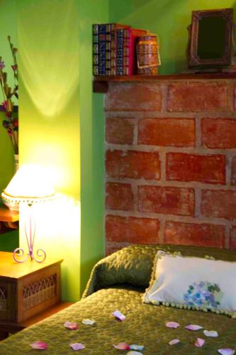 a bedroom with a brick wall with a bed and a lamp at Fuente De Las Anjanas in Estrada